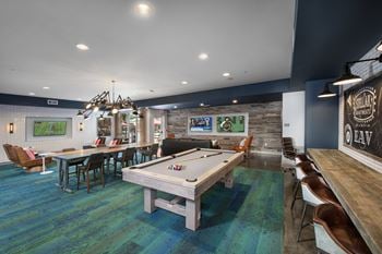 A recreation room with a pool table and ping pong table